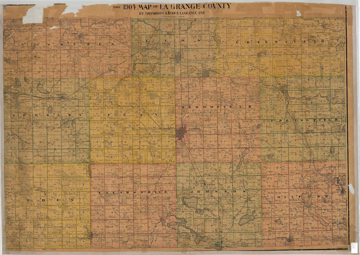 A large printed county map of 1904, headed THE 1904 MAP OF LA GRANGE COUNTY BY SHEPARDSON & RERICK, LAGRANGE, IND. The eleven townships are washed in pink, yellow and buff and lettered in spaced capitals across their faces, each divided into numbered one mile sections with roads, streams, lakes and railway lines drawn across them and small black squares for buildings. The sheet is torn and patched along its top edge.